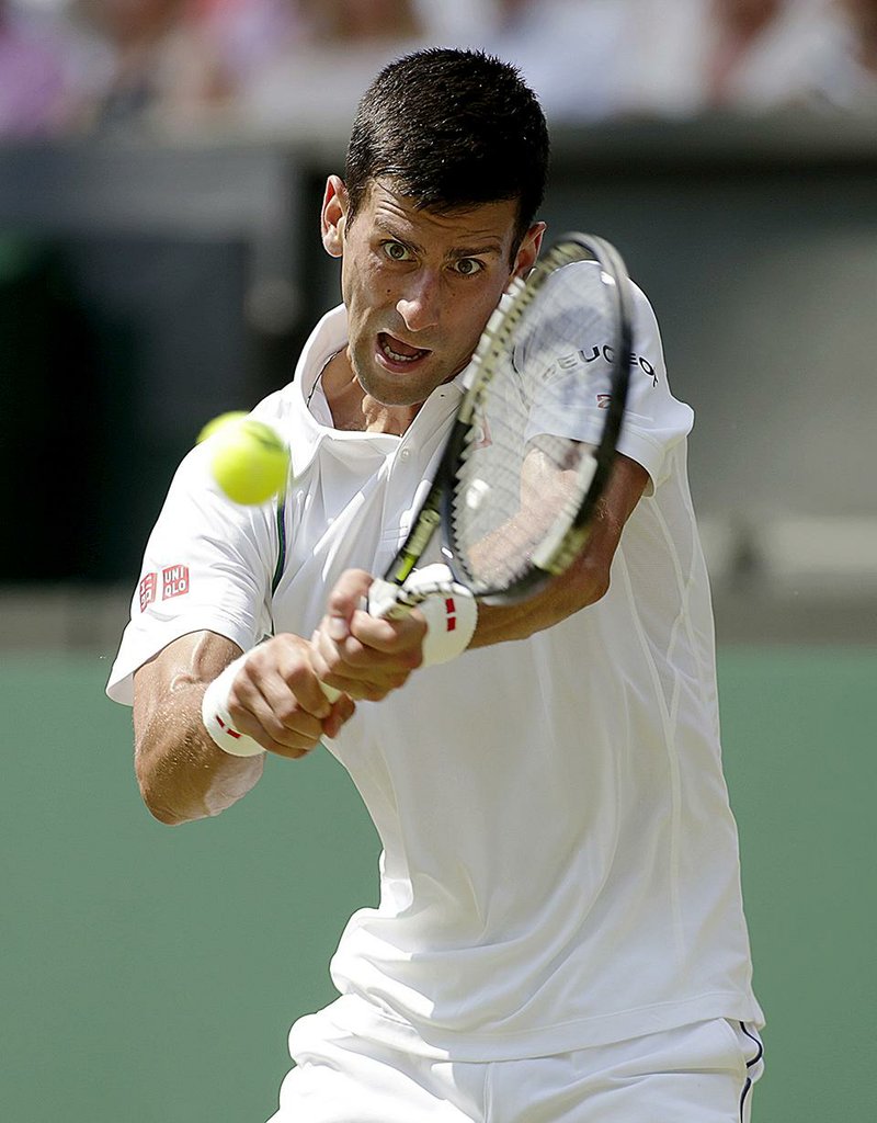 Defending champion and top-seeded Novak Djokovic of Serbia returns a shot to Jarkko Nieminen of Finland in a three-set victory Wednesday to reach the third round at Wimbledon.
