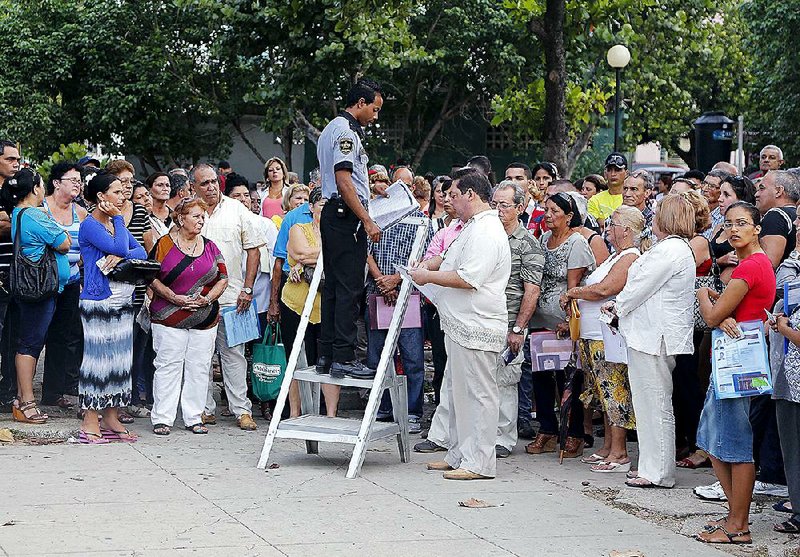 People applying for U.S. visas wait for their names to be called Wednesday by an employee of the U.S. Interests Section in Havana. 