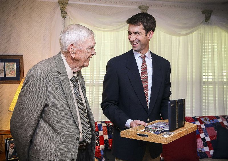 Neal Johnson, 89, talks with U.S. Sen. Tom Cotton, R-Ark., on Wednesday at Johnson’s Greenbrier home, where Cotton presented the World War II veteran with eight reissued medals that Johnson had lost over time, including a Bronze Star and a Purple Heart.