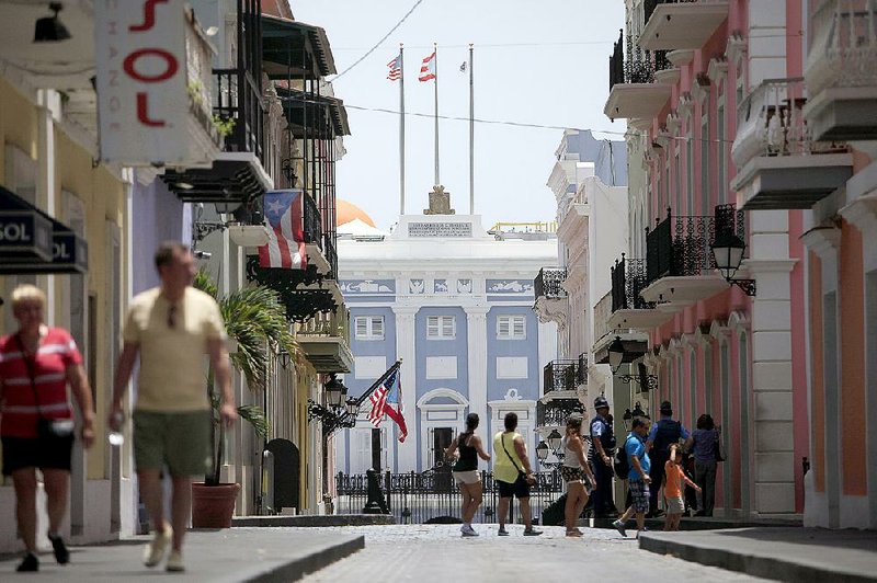 Pedestrians pass near the governor’s mansion in Old San Juan, Puerto Rico, on Monday. 
