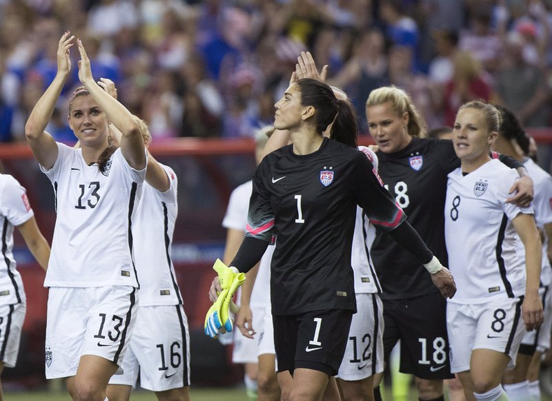United States' Alex Morgan (13) and goalkeeper Hope Solo (1) salute the crowd after the U.S. team defeated Germany 2-0 in a semifinal in the Women's World Cup soccer tournament, Tuesday, June 30, 2015, in Montreal, Canada. 