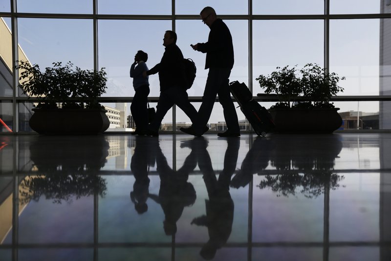 In this Feb. 14, 2013 file photo, Travelers pass through a corridor at Philadelphia International Airport in Philadelphia. The U.S. government is investigating possible collusion between major airlines to limit available seats, which keeps airfares high, according to a document obtained by The Associated Press. 