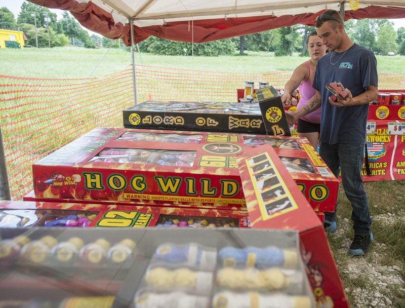 File Photo/NWA Democrat-Gazette/ANTHONY REYES &#8226; @NWATONYR Samantha Bishop and Josh Bishop, both of Springdale, browse through the selection Monday at Jake&#8217;s Firework at West End Street and Sunset Avenue in Springdale.