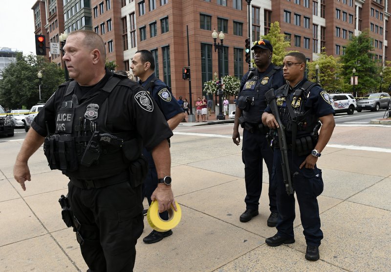 Police tell members of the media to move from their positions near the Washington Navy Yard in Washington on Thursday, July 2, 2015. A lockdown was underway Thursday morning across the Washington Navy Yard campus after reports of shots fired, but a senior law enforcement official said those reports had not been confirmed. 