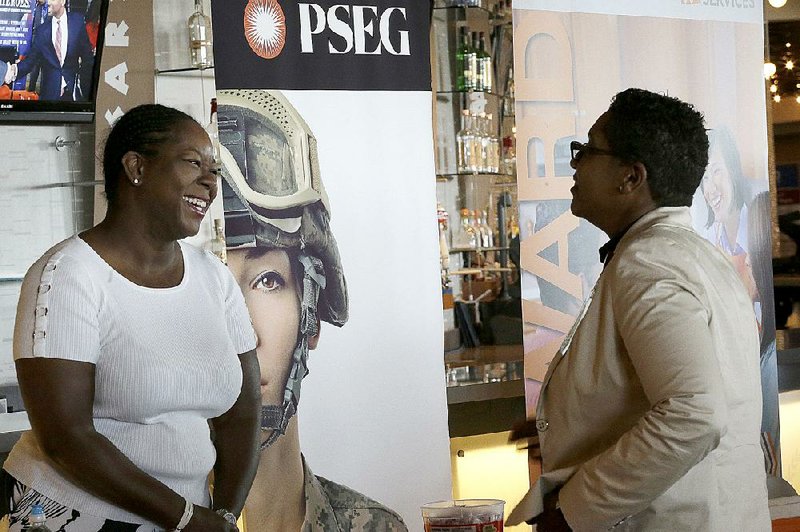 Sophia Lewis (left), with utility company PSEG Long Island, speaks to a job seeker during a job fair Tuesday at Citi Field in New York.