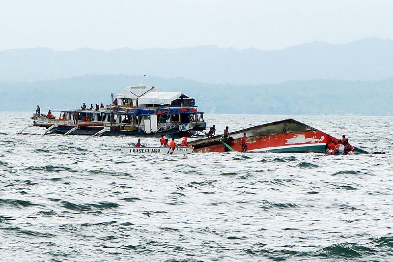 Rescuers help passengers from a ferryboat that overturned Thursday off Ormoc city in the Philippines. 