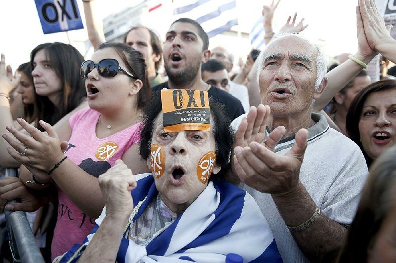 A Greek demonstrator with “no” stickers on her face joins others Friday at an Athens rally urging a vote of no in Sunday’s referendum on creditors’ proposals. 