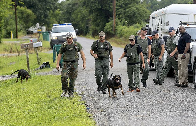 An Arkansas Department of Correction K-9 unit searches Friday for escapee Jason Satterfield near Eureka Gardens and Ziegler roads in Pulaski County before his capture on Arkansas 161.