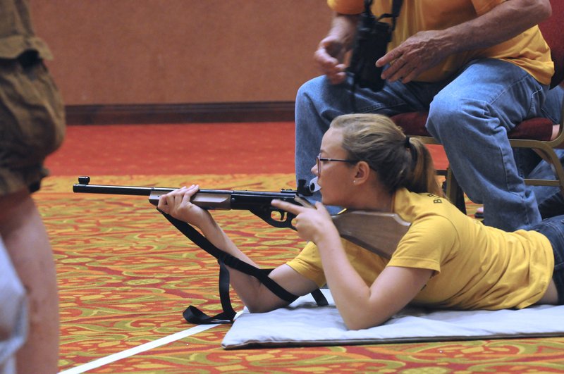 Emma Tichy, a competitor from North Dakota, practices her marksmanship Friday with her coach, Dan Geurts in Rogers. Sixty-eight teams representing 18 states are gunning for glory in the 50th annual BB Gun Championship Match at the John Q. Hammons Center.