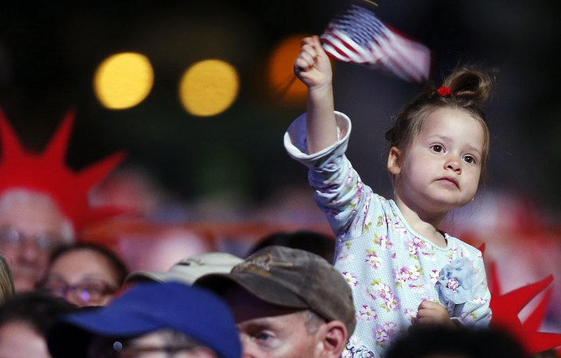 A young girl waves a flag during rehearsal for the annual Boston Pops orchestra Fourth of July concert at the Hatch Shell in Boston, Friday, July 3, 2015.