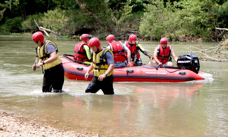 Swift water rescue workers from Siloam Springs, Centerton, and Highfill are pictured here searching for the body of Randy Barton, 55, who went under in the Illinois River on Tuesday afternoon and was found on Wednesday around 2:30 p.m.