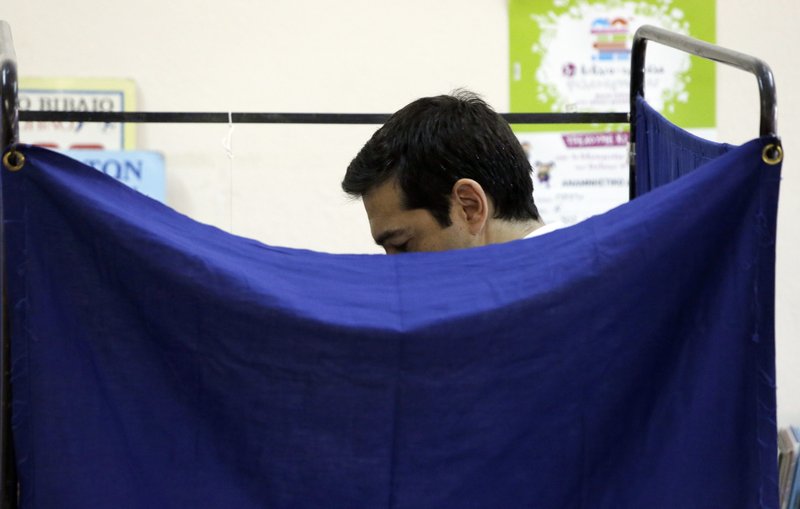 Greece's Prime Minister Alexis Tsipras casts his vote at a polling station in Athens, Sunday, July 5, 2015. Greeks began voting early Sunday in a closely-watched, closely-contested referendum, which the government pits as a choice over whether to defy the country's creditors and push for better repayment terms or essentially accept their terms, but which the opposition and many of the creditors paint as a choice between staying in the euro or leaving it. 