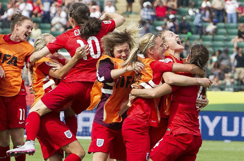 Members of the English women’s team celebrate a penalty kick goal against Germany during overtime Sautday in the Women’s World Cup third-place match in Edmonton, Alberta. It was England’s first victory over Germany in 21 meetings.