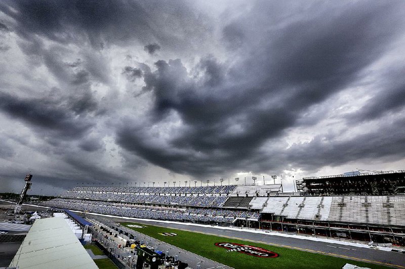Storm clouds tower over Daytona International Speedway in Daytona Beach, Fla., on Saturday just before qualifying for today’s NASCAR Sprint Cup race was canceled. Dale Earnhardt Jr. will start in the pole position by default after posting the fastest time in Friday’s practice, a move suggested by his crew chief, Greg Ives.