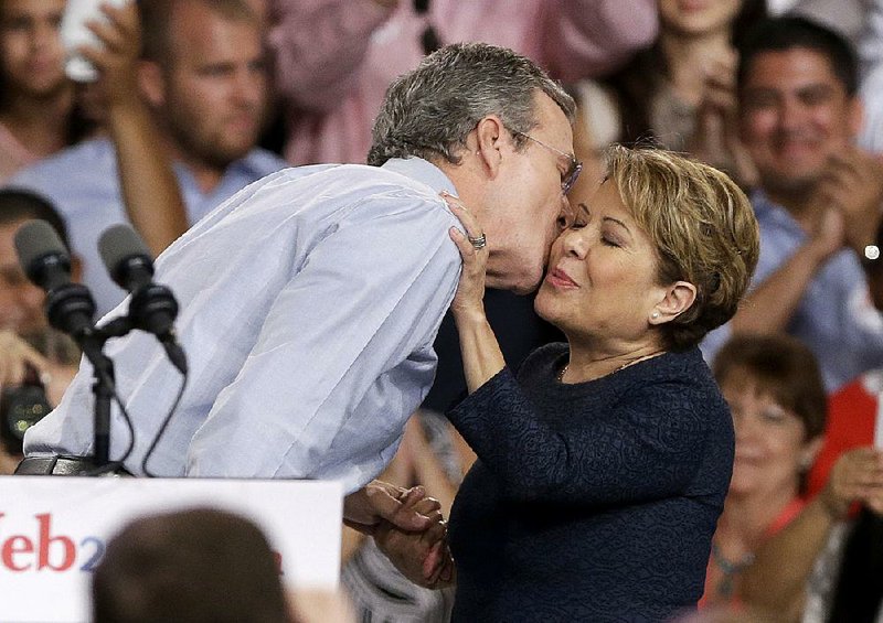 Jeb Bush, shown kissing his wife, Columba, on June 15 after announcing his bid for the Republican presidential nomination, established a firm after leaving the Florida governor’s office that made more than $33 million from 2007-2013. 