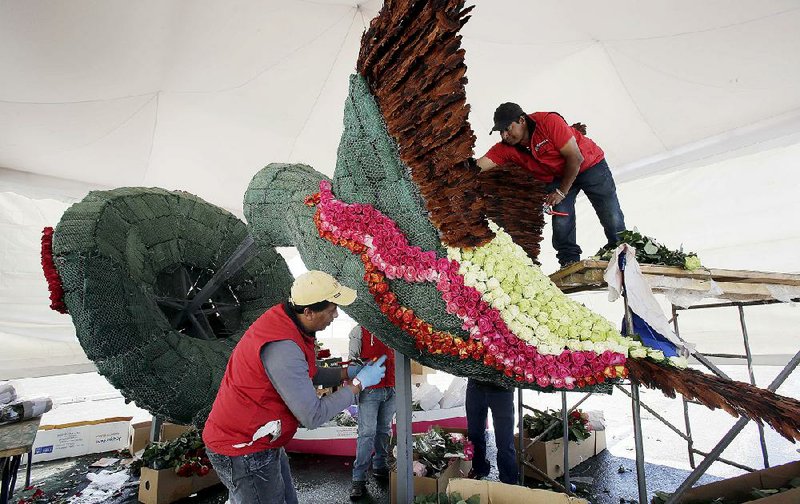 Workers prepare a sculpture of a hummingbird, which will be covered with flowers, on Saturday ahead of the pope’s arrival this week in Quito, Ecuador.