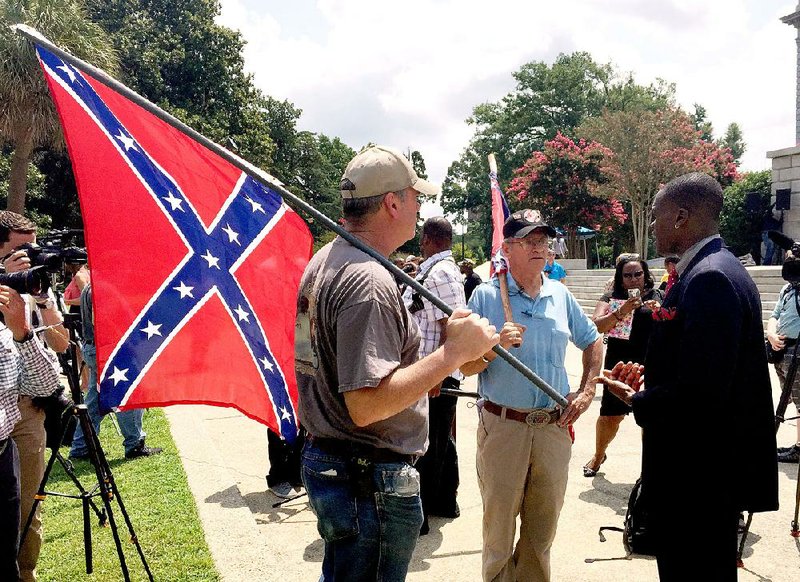 Randy Saxon (left) and Wayne Whitfield (center), both of Anderson, S.C., discuss the Confederate flag Monday on the Statehouse grounds in Columbia, S.C., with Brodrick Hall of Atlanta.