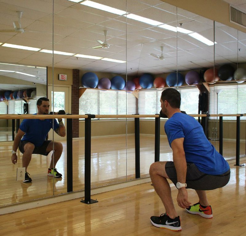 David S. Martinous doesn’t arch his lower back during the squatting part of the Hot Potato Squat. This is step 2 of the exercise.