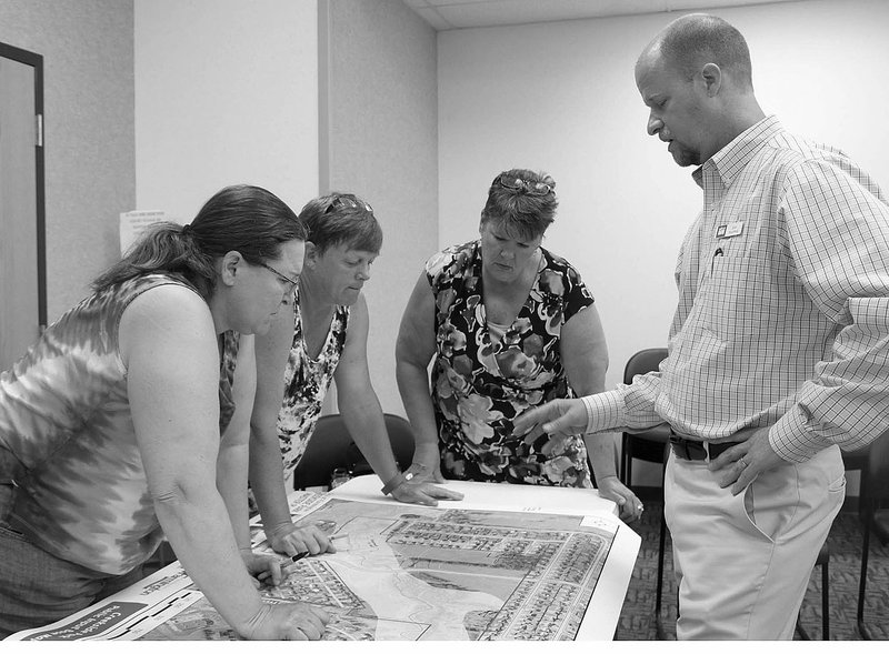 LYNN KUTTER ENTERPRISE-LEADER Tracy Quade, left, Laurie Adkins and Devis Fruchtl write down ideas they have to improve Creekside Park in Farmington during a public workshop held last week at Farmington City Hall. The three women live in houses near the park. Erin Rushing with Alta Planning and Design is project manager to help develop a new master plan for the park.