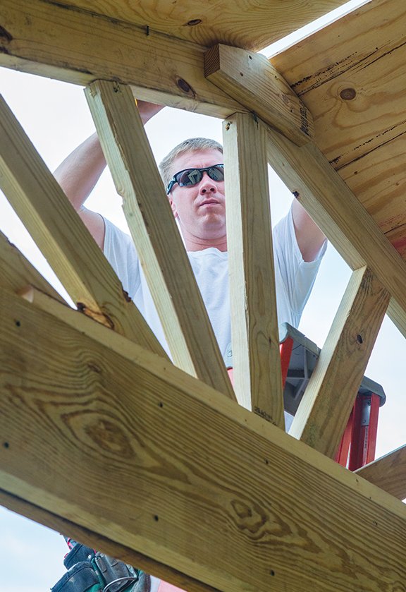 Ryan Webb of Conway, a member of City Church, works on the decorative front of the gazebo built in the backyard of Bethlehem House, a transitional homeless shelter in Conway. City Church built the gazebo with volunteers from CityReach, a national organization.