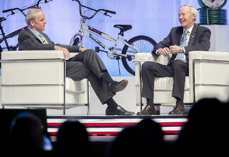 Dan Bartlett (left), Wal-Mart’s executive vice president for corporate affairs, and Gov. Asa Hutchinson head up a question-and-answer session Wednesday at Bentonville High School. Hutchinson said that while he knows the retail giant must treat all states fairly, Arkansas is like “the oldest child. We want our share of attention.”