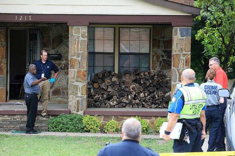 Little Rock Detective Lt. Glenn King (left) talks with officers at the home of Fred Pohnka Jr., 68, whose body was found there Wednesday. 