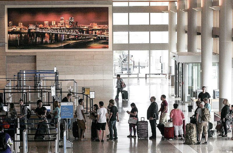 Passengers check in for flights Wednesday morning at Bill and Hillary Clinton National Airport/Adams Field in Little Rock. United Airlines flights at all U.S. airports were grounded early in the day because of a computer glitch. 