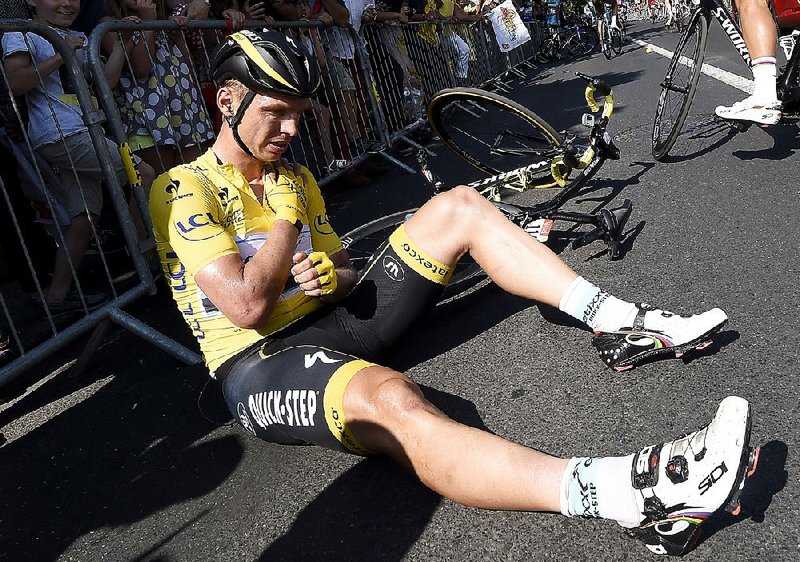 Overall leader Tony Martin of Germany holds his broken left collarbone Thursday after crashing on an uphill section near the finish of the sixth stage in Le Havre, France. After finishing the race with a 12-second lead, Martin said he is pulling out of the competition.