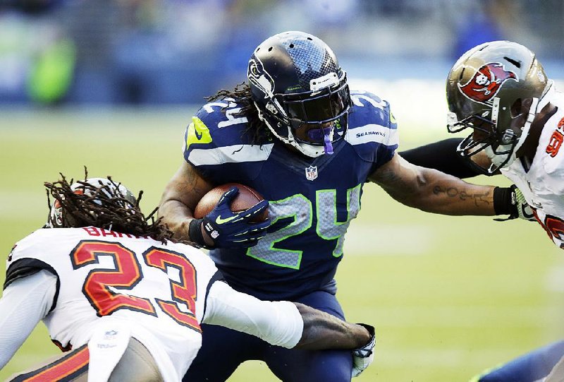 Seattle Seahawks running back Marshawn Lynch (24) runs through Tampa Bay Buccaneers' Mark Barron (23) and Tampa Bay Buccaneers' William Gholston in the second half of an NFL football game Sunday, Nov. 3, 2013, in Seattle. The Seahawks won 27-24 in overtime. (AP Photo/Stephen Brashear)