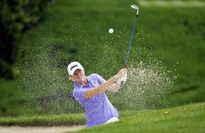 Former Arkansas Razorback Stacy Lewis blasts out of a bunker on the eighth hole at the U.S. Women’s Open in Lancaster, Pa. Lewis shot a 1-under 69 Thursday, which left her three shots off the lead.