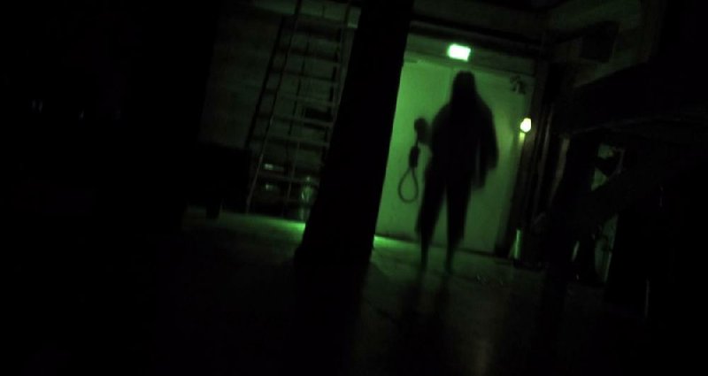 A shadowy figure lumbers after some really dumb teenagers in the “found footage” horror film The Gallows.