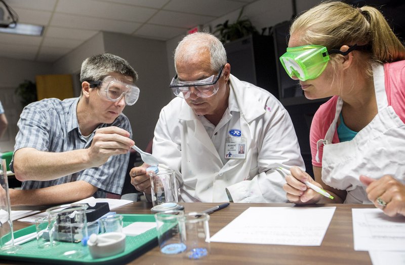 Kory Roberts (from left), Robert Lee, both Rogers High School teachers, and Becky Caswell, Gentry High School teacher, measure samples of copper(II) sulfate pentahydrate Thursday at the Northwest Education Service Cooperative in Farmington. Science teachers from Benton and Washington counties learned different approaches for teaching students about solutions that fit with the direction of the Next Generation Science Standards.