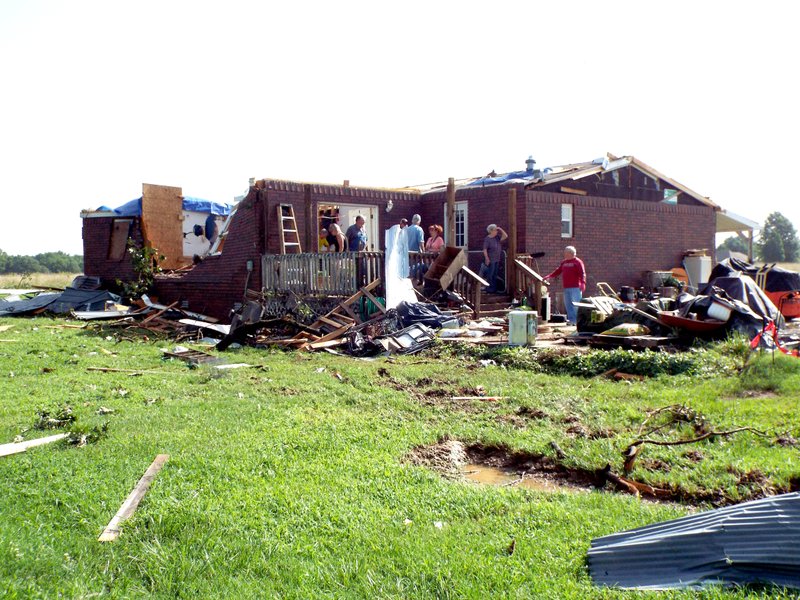 Photo by Randy Moll
Assisted by family members and friends, Curtis and Cheryl Gallaway were picking up the pieces after their home at 145 WPA Rd., in Gentry, was destroyed by the winds of a storm which passed through at about 6 p.m. on Thursday, July 9, 2015. Area residents reported seeing a tornado in the area of the Gallaway home.