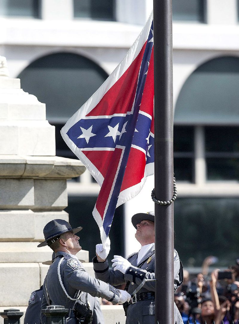 Members of a South Carolina Highway Patrol honor guard take down the Confederate battle flag Friday on the grounds of the South Carolina Statehouse, where it had flown since 1961. 