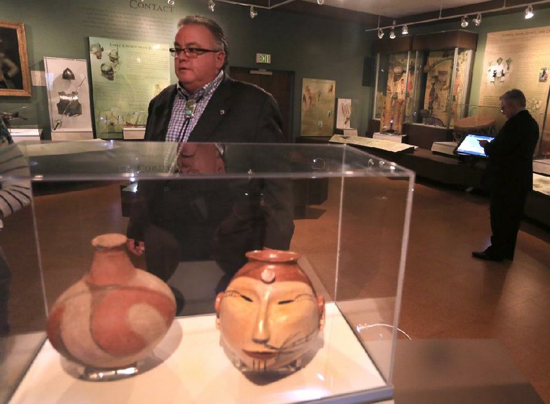 John Berrey, chairman Quapaw tribe, walks past an old piece of Quapaw pottery (left) and a recent one at the American Indian exhibit in the Historic Arkansas Museum in Little Rock.