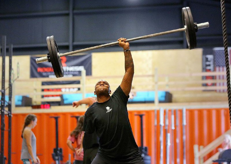 Sgt. 1st Class Michael Smith lifts 105 pounds over his head during cross-training Wednesday at Wellness Revolution CrossFit in Little Rock.