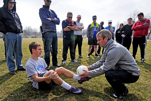 University of Arkansas women's soccer coach Colby Hale, right, demonstrates an exercise to help players recognize the sweet spots on their feet for kicking the ball with Anthony Euculano while leading an Arkansas State Soccer Association coaching course hosted by the Rogers Activity Center on Sunday March 9, 2014 in Rogers. 