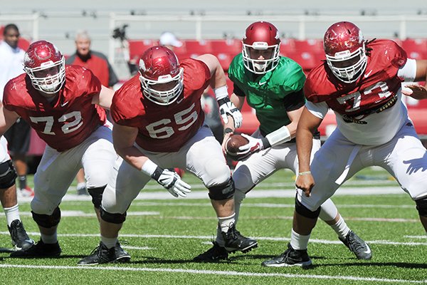 Arkansas offensive linemen Frank Ragnow (72), Mitch Smothers (65) and Sebastian Tretola (73) block while quarterback Brandon Allen runs a play during practice Saturday, April 4, 2015, at Razorback Stadium in Fayetteville. 