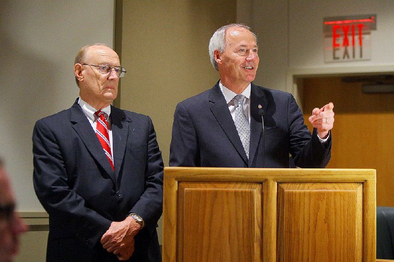 Gov. Asa Hutchinson (right) introduces Joe Morgan on Wednesday as the newest member of the Arkansas Game and Fish Commission at the agency’s headquarters in Little Rock.