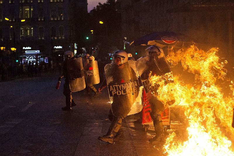 Greek riot police dodge firebombs Wednesday during clashes with anti-austerity protesters in Athens in the first significant protest violence since the leftist Syriza government took power in January.