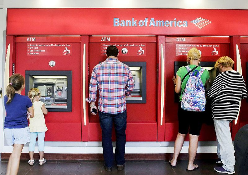 Bank of America customers use ATMs on Monday at a branch in New York. The bank on Wednesday reported a quarterly profit of $5.3 billion. 