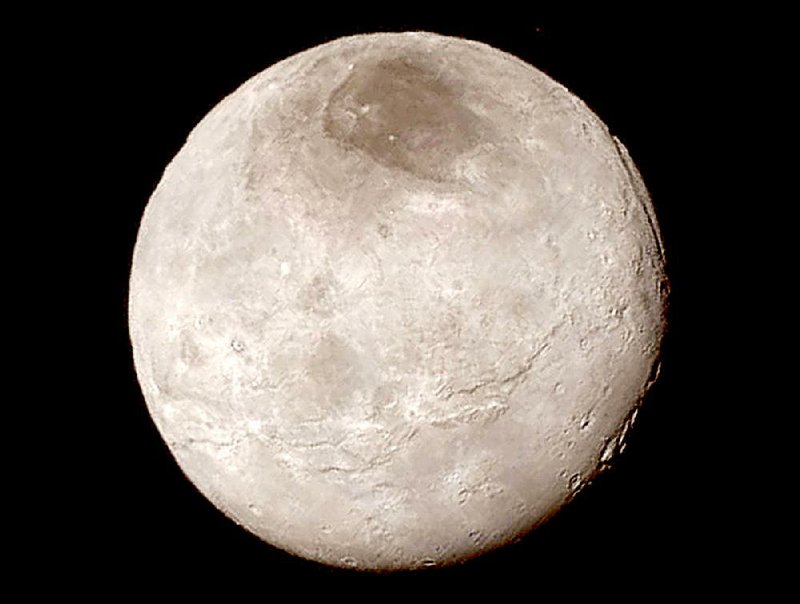 Pluto’s largest moon, Charon, has deep chasms in this image taken by the New Horizons spacecraft during its flyby of Pluto and released Wednesday by NASA. A close-in photo of Pluto showed towering ice mountains. “This exceeds what we came for,” deputy project scientist Cathy Olkin said.