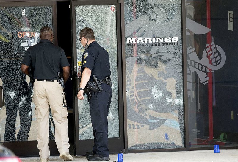 Police officers enter the bullet-riddled recruiting center in Chattanooga where a gunman first opened fire Thursday morning before carrying out a second, fatal attack at a Navy and Marine reserve center a few miles away. 