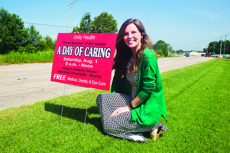 Brooke Pryor, marketing director for Unity Health in Searcy, puts out signs announcing A Day of Caring. Signs around Searcy indicate sponsors for the event, and Pryor said the event’s mission would be impossible without the community’s support.