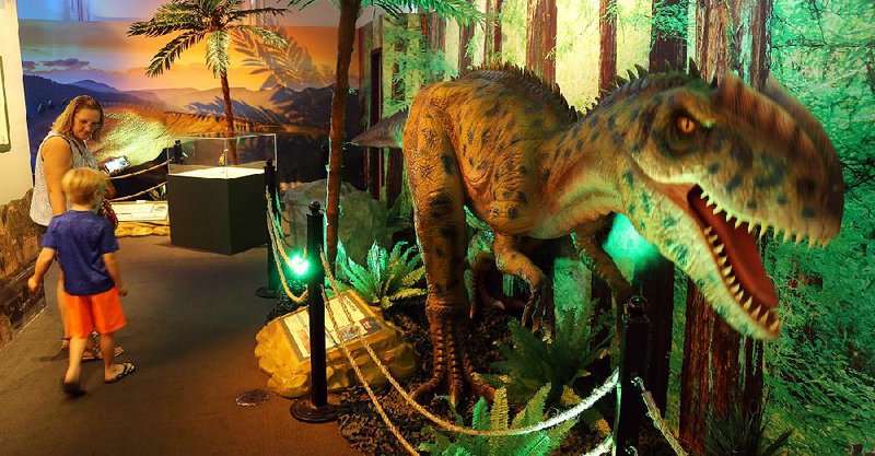 Visitors don’t always linger as they pass a moving model of a Neovenator (“new hunter”), an allosauroid dinosaur. The model is part of an exhibit at the Clinton Presidential Center titled “Dinosaurs Around the World.”
