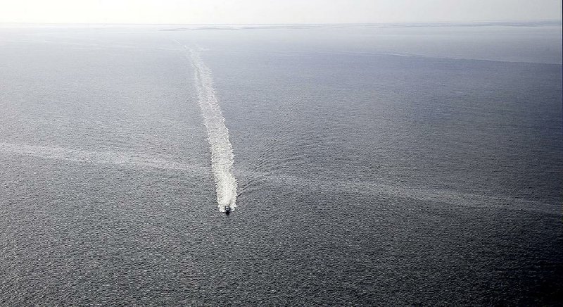 A boat crosses an oil sheen in March at the former location of a Taylor Energy oil rig in the Gulf of Mexico. 