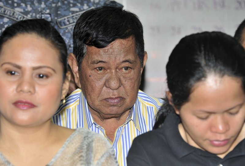 In this Monday March 26, 2012, file photo, Andal Ampatuan Sr., center, a powerful Filipino clan leader who is a suspect in a 2009 massacre, listens during his arraignment on electoral sabotage at the Pasay city regional trial court, south of Manila, Philippines. Ampatuan's lawyer, Salvador Panelo says his client died overnight on Friday, July 17, 2015, in a government hospital. 