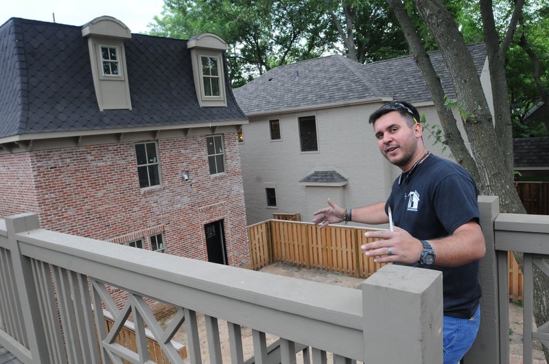 Juan Quiros shows two homes June 26 he and his crew have built in downtown Bentonville, in conjunction with Lamplighter Restoration. The homes are new but are built to resemble older styles of homes. Though development has brought many big-city amenities to Bentonville, residential developers said they’re committed to maintaining a small-town atmosphere by marrying historical characteristics with modern features.