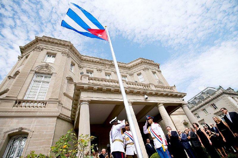 Cuban Foreign Minister Bruno Rodriguez (right of center) applauds with other dignitaries Monday after raising the Cuban flag over their new embassy in Washington.
