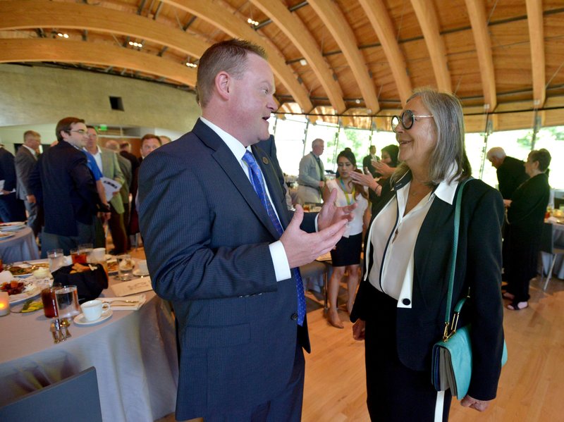 Greg Hines, Rogers mayor, chats Monday with Alice Walton as the Northwest Arkansas Council celebrates its 25th anniversary at its annual meeting at Crystal Bridges Museum of American Art in Bentonville.